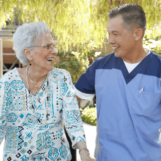 Older woman walking with a male healthcare worker