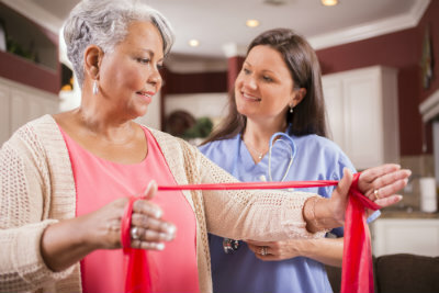 Elderly woman holding a ribbon with a nurse