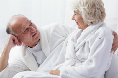 Elderly couple looking at each other while wearing robe