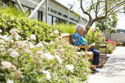 Old woman reading books outside